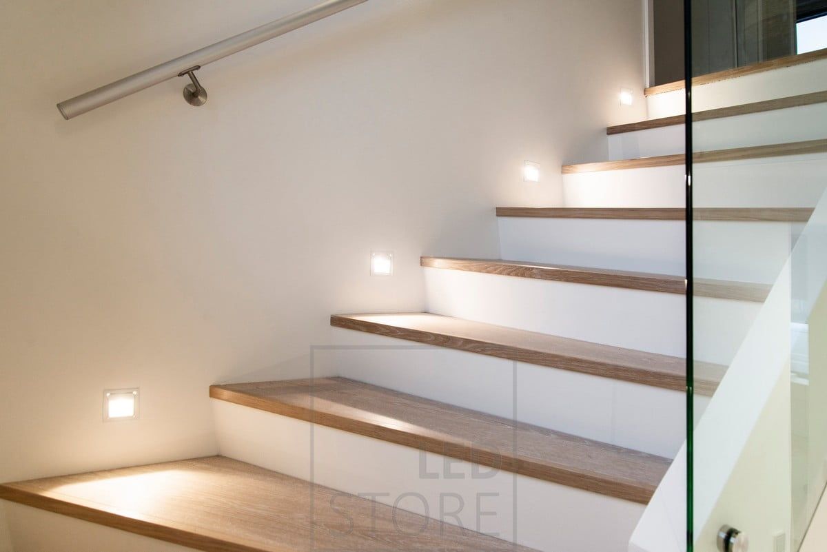 Soft light on the steps of the staircase with recessed wall luminaires.